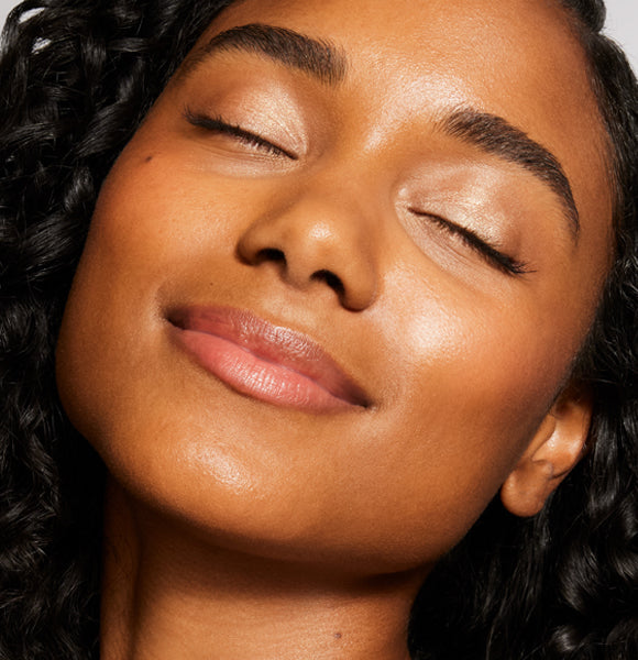 a model smiling and wearing sunscreen