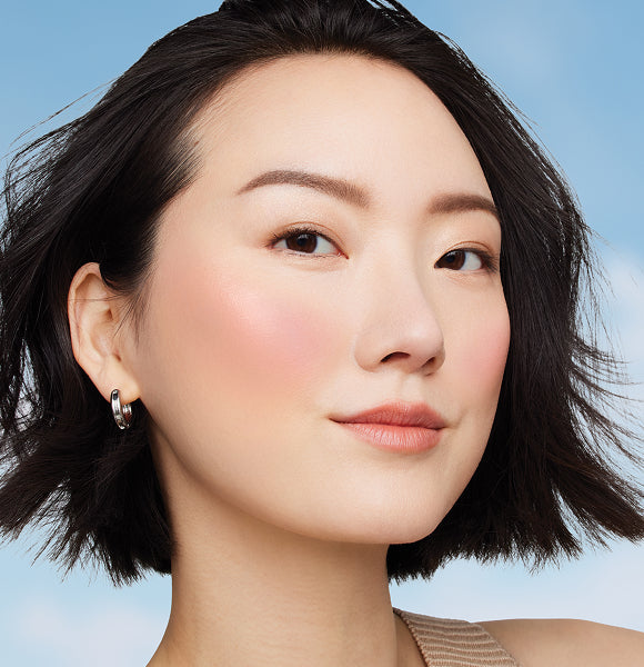 image of woman smiling wearing bronzed makeup
