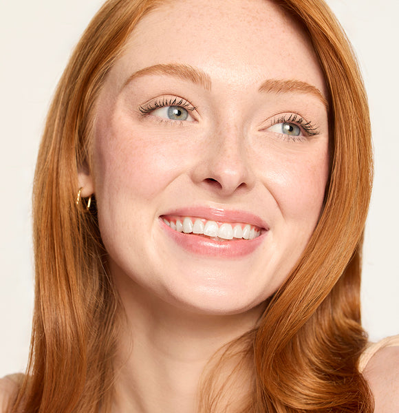 image of woman smiling wearing bronzed makeup