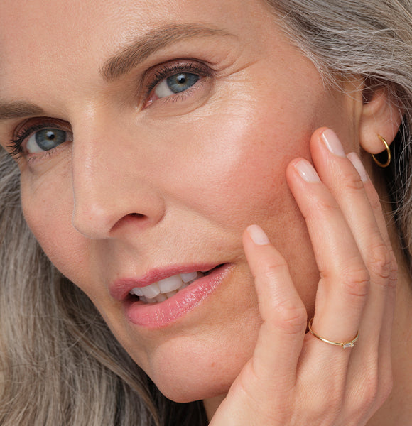 image of woman smiling holding face bronzing powder